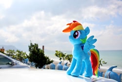 Size: 1024x682 | Tagged: safe, artist:nekokevin, character:rainbow dash, species:pegasus, species:pony, beach, car, cloud, female, irl, mare, photo, plushie, smiling, solo, spread wings, wings