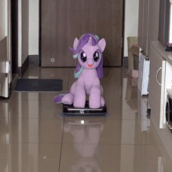 Size: 640x640 | Tagged: safe, artist:nekokevin, character:starlight glimmer, species:pony, species:unicorn, series:nekokevin's glimmy, animated, behaving like a cat, female, happy, irl, it's coming right at us, looking at you, mare, open mouth, photo, plushie, riding, roomba, sitting, solo, sound, underhoof, webm