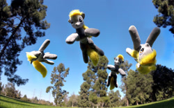 Size: 1534x956 | Tagged: safe, artist:agatrix, artist:earthenhoof, character:derpy hooves, species:pegasus, species:pony, clone, flying, grass, irl, it's coming right at us, outdoors, park, photo, plushie, tree