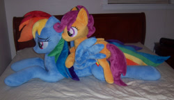 Size: 1379x800 | Tagged: safe, artist:agatrix, artist:penniesponyplushies, photographer:vile-flesh, character:rainbow dash, character:scootaloo, species:pegasus, species:pony, bed, irl, photo, plushie, ponies in real life, ponies riding ponies