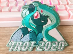Size: 1277x957 | Tagged: safe, artist:pearlyiridescence, oc, oc only, oc:proxy server, species:pony, convention, convention mascots, craft, cute, embroidery, female, keyboard, mascot, one eye closed, photo, smiling, solo, trotcon, wink, winking at you