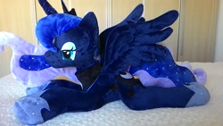 Size: 1600x900 | Tagged: safe, artist:masha05, character:princess luna, species:alicorn, species:pony, female, irl, jewelry, lidded eyes, mare, photo, plushie, prone, regalia, solo, spread wings, wings