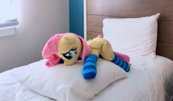 Size: 1280x746 | Tagged: safe, artist:dawning love, artist:natureshy, character:fluttershy, bed, clothing, heart eyes, irl, lying on bed, lying on pillows, photo, plushie, socks, solo, striped socks, wingding eyes