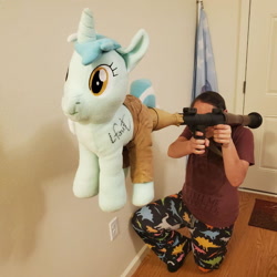 Size: 942x942 | Tagged: safe, artist:hoppip, character:lyra heartstrings, species:human, species:pony, species:unicorn, g4, clothing, duo, female, irl, irl human, lyra plushie, mare, not salmon, pants, photo, plushie, rocket launcher, rpg-7, wat