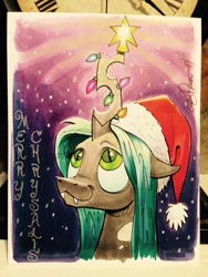 Size: 599x798 | Tagged: safe, artist:andypriceart, character:queen chrysalis, :3, christmas, christmas lights, clothing, cute, cutealis, fangs, hat, looking up, santa hat, smiling, solo, traditional art