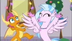 Size: 630x360 | Tagged: safe, screencap, character:silverstream, character:smolder, species:classical hippogriff, species:dragon, species:hippogriff, episode:the hearth's warming club, g4, my little pony: friendship is magic, dragoness, duo, female, hearth's warming, jewelry, necklace, spread wings, wings