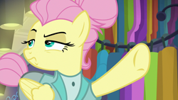 Size: 1280x720 | Tagged: safe, screencap, character:fluttershy, species:pegasus, species:pony, episode:fake it 'til you make it, alter ego, alternate hairstyle, clothing, female, folded wings, hair bun, lidded eyes, manehattan, mare, pointing, raised eyebrow, raised hoof, rarity for you, severeshy, solo, tail bun, underhoof, wings