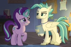 Size: 1145x766 | Tagged: safe, screencap, character:starlight glimmer, character:terramar, species:classical hippogriff, species:hippogriff, species:pony, species:unicorn, episode:student counsel, book, cropped, duo, embarrassed, female, magic, magic aura, male, mare, raised eyebrow, raised hoof, raised leg, sheepish grin, silverstream's room, terramar is not amused, unamused