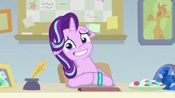 Size: 1920x1080 | Tagged: safe, screencap, character:starlight glimmer, species:pony, species:unicorn, episode:student counsel, awkward smile, bracelet, cute, female, floppy ears, food, geode, glimmerbetes, inkwell, jewelry, looking at you, mare, photo, quill, sitting, solo, starlight's office