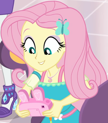 Size: 853x970 | Tagged: safe, screencap, character:fluttershy, character:rarity, equestria girls:holidays unwrapped, g4, my little pony:equestria girls, bunny ears, camera, canterlot mall, chair, clothing, cropped, cute, dashing through the mall, dress, female, flower, geode of fauna, gift giving, hairclip, happy, jewelry, looking down, magical geodes, mall, necklace, shyabetes, sitting, smiling, table, waistband