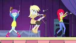 Size: 1280x720 | Tagged: safe, screencap, character:derpy hooves, equestria girls:rainbow rocks, g4, my little pony:equestria girls, background human, blueberry pie, cowbell, kimber benton, musical instrument, musical saw, raspberry fluff, saw, smiling, stage, the muffins, triangle, trio