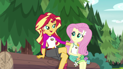 Size: 1280x720 | Tagged: safe, screencap, character:fluttershy, character:sunset shimmer, equestria girls:legend of everfree, g4, my little pony:equestria girls, camp everfree outfits, clothing, embrace the magic, log, mama sunset, motherly, open mouth, scenery, singing, sitting
