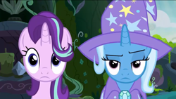 Size: 1136x640 | Tagged: safe, screencap, character:starlight glimmer, character:trixie, species:pony, species:unicorn, episode:to change a changeling, g4, my little pony: friendship is magic, cape, clothing, hair flip, hair over one eye, hat, raised eyebrow, trixie is not amused, trixie's cape, trixie's hat, unamused