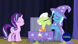 Size: 1920x1080 | Tagged: safe, screencap, character:granny smith, character:starlight glimmer, character:trixie, species:earth pony, species:pony, species:unicorn, episode:on the road to friendship, cape, chains, chest, clothing, eyes closed, female, hat, mare, smiling, stage, trixie's cape, trixie's hat