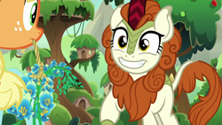 Size: 1280x720 | Tagged: safe, screencap, character:applejack, character:autumn blaze, species:earth pony, species:kirin, species:pony, episode:sounds of silence, g4, my little pony: friendship is magic, awwtumn blaze, cloven hooves, cute, duo, female, flower, foal's breath, grin, happy, mare, mouth hold, smiling, tree, treehouse, village