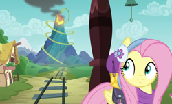 Size: 1775x1080 | Tagged: safe, screencap, character:fluttershy, species:pegasus, species:pony, episode:dungeons & discords, clothing, earmuffs, female, looking back, mare, ponyville, solo, train, train tracks, volcano