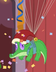 Size: 490x630 | Tagged: safe, screencap, character:gummy, episode:best gift ever, episode:the great escape room, g4, my little pony: friendship is magic, alligator, christmas, clothing, confetti, cropped, hat, hearth's warming shorts, holiday, male, parachute, santa hat