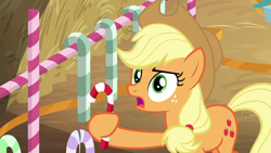Size: 1280x720 | Tagged: safe, screencap, character:applejack, species:earth pony, species:pony, episode:the great escape room, candy, candy cane, female, food, freckles, hay, holding, mare, solo