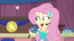 Size: 1280x720 | Tagged: safe, screencap, character:fluttershy, episode:best in show: the victory lap, g4, my little pony:equestria girls, best in show logo, geode of fauna, magical geodes, microphone, open mouth, smiling, solo