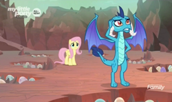 Size: 1490x884 | Tagged: safe, screencap, character:fluttershy, character:princess ember, species:dragon, species:pegasus, species:pony, episode:sweet and smoky, g4, my little pony: friendship is magic, discovery family logo, dragon egg, dragon lord ember, dragoness, duo, egg, female, holes, mare, nest, scratching, spread wings, wings