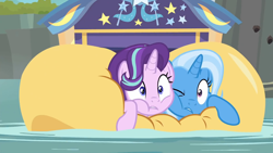 Size: 1920x1080 | Tagged: safe, screencap, character:starlight glimmer, character:trixie, species:pony, species:unicorn, episode:on the road to friendship, cheek squish, cheek to cheek, female, friendshipping, ghastly gorge, i guess we're stuck together, inflatable, inflatable raft, mare, one eye closed, prone, raft, river, squished, squishy cheeks, trixie's wagon, wagon, we're friendship bound