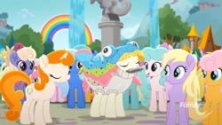 Size: 1699x956 | Tagged: safe, screencap, character:kersplash, species:earth pony, species:pony, species:unicorn, friendship is magic: rainbow roadtrip, g4, my little pony: friendship is magic, animal costume, background pony, clothing, costume, discovery family logo, eyes closed, female, fish, fish costume, fountain, harmonica, hope hollow, male, mare, musical instrument, outdoors, playing instrument, rainbow, rainbow trout (character), stallion, statue, tree, unnamed pony