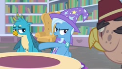 Size: 1920x1080 | Tagged: safe, screencap, character:gallus, character:grampa gruff, character:trixie, species:griffon, species:pony, species:unicorn, episode:a horse shoe-in, g4, my little pony: friendship is magic, bookshelf, cape, clothing, couch, female, hat, male, mare, quadrupedal, trixie's cape, trixie's hat