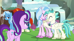 Size: 1920x1080 | Tagged: safe, screencap, character:mudbriar, character:silverstream, character:starlight glimmer, character:sunburst, character:terramar, character:trixie, species:classical hippogriff, species:hippogriff, species:pony, species:unicorn, episode:student counsel, balloon, brother and sister, butt, cute, diastreamies, eyes closed, female, folded wings, hug, jewelry, male, mare, necklace, plot, siblings, smiling, stallion, terrabetes, tree, wings