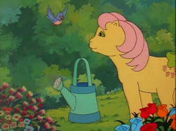 Size: 935x701 | Tagged: safe, screencap, character:posey, species:bird, episode:fugitive flowers, g1, my little pony 'n friends, bluebird, bow, cute, flower, garden, poseybetes, tail bow, watering can