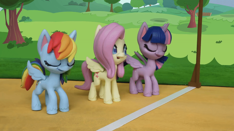 Size: 800x450 | Tagged: safe, screencap, character:fluttershy, character:rainbow dash, character:twilight sparkle, character:twilight sparkle (alicorn), species:alicorn, species:pegasus, species:pony, g4.5, my little pony: stop motion short, my little pony:pony life, animated, eyes closed, gif, grass, smiling, starting line, stop motion, the great race (short), tree, wings