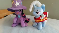Size: 1328x747 | Tagged: artist needed, source needed, useless source url, safe, character:trixie, character:twilight sparkle, species:pony, species:unicorn, 4de, cape, clothing, female, hat, irl, mare, photo, plushie, swap, trixie's cape, trixie's hat, wells fargo