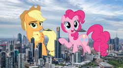 Size: 2500x1400 | Tagged: safe, artist:dashiesparkle, artist:theotterpony, character:applejack, character:pinkie pie, species:earth pony, species:pony, australia, city, clothing, cowboy hat, female, freckles, giant pony, hat, helicopter, highrise ponies, irl, macro, mare, melbourne, open mouth, photo, ponies in real life, raised hoof, stetson, story in the source