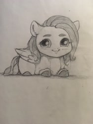 Size: 1536x2048 | Tagged: safe, artist:miokomata, character:fluttershy, species:pegasus, species:pony, g4, cheek fluff, chibi, cute, ear fluff, female, freckles, freckleshy, grayscale, looking at you, lying down, mare, monochrome, pencil drawing, prone, shyabetes, smiling, smiling at you, solo, traditional art
